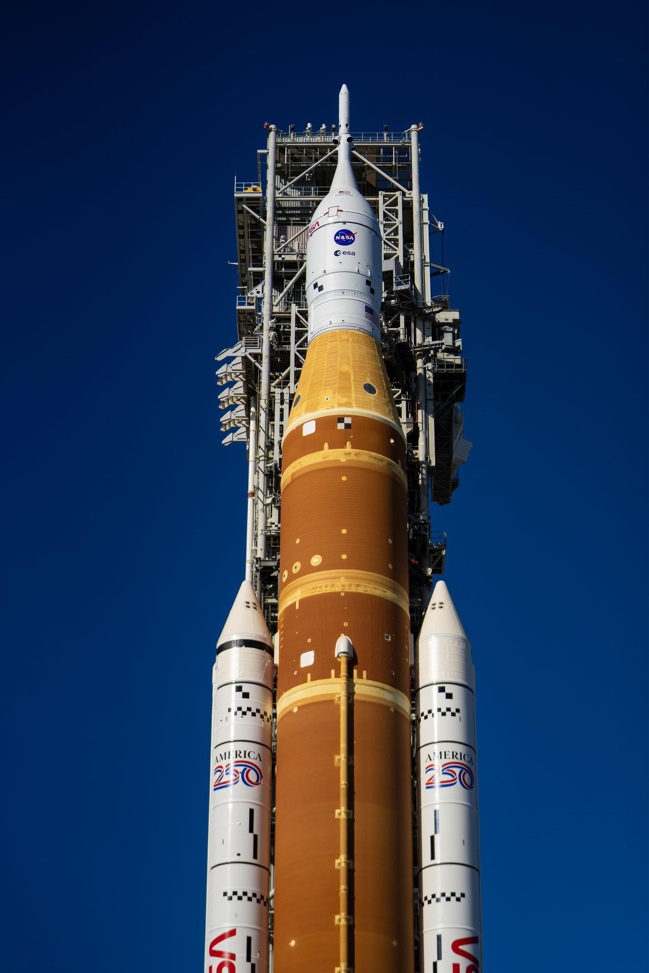 This image shows NASA’s SLS (Space Launch System) and Orion spacecraft rolling out of the Vehicle Assembly Building at NASA’s Kennedy Space Center. NASA's massive Crawler-Transporter, upgraded for the Artemis program, carries the powerful SLS rocket and Orion spacecraft on the Mobile Launcher from the Vehicle Assembly Building to Launch Pad 39B at Kennedy Space Center   in preparation for the Artemis II mission.  